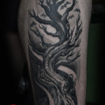 Tattoo su coscia rappresentatnte albero bio-organico in bianco e nero