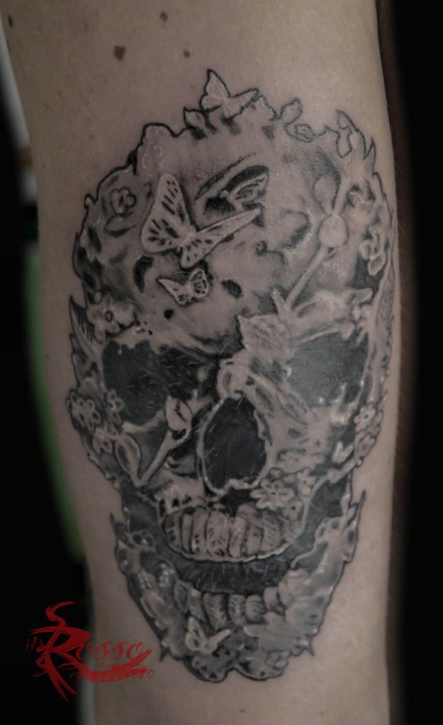 Tattoo teschio creato con elementi floreali e farfalle